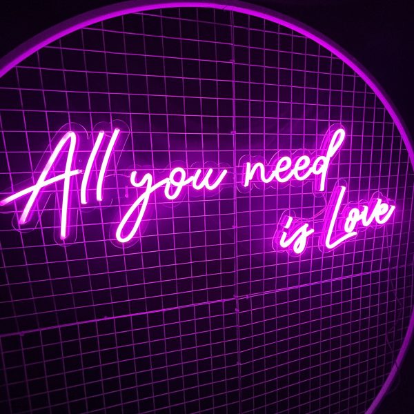 All you need is love neon sign on a white round mesh backdrop