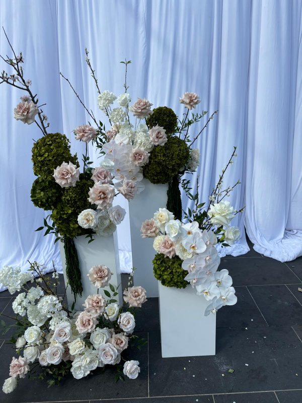 set of 3 white plinths with flowers placed on top